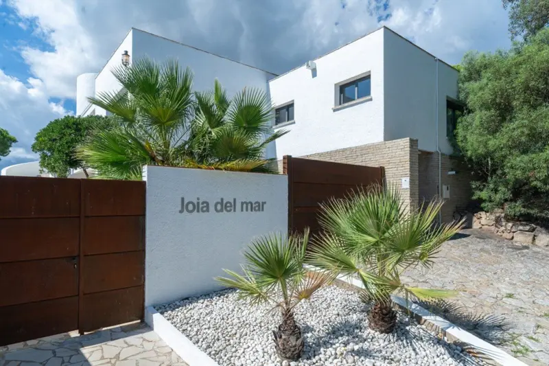 Villa entrance with Joia del Mar sign and palms